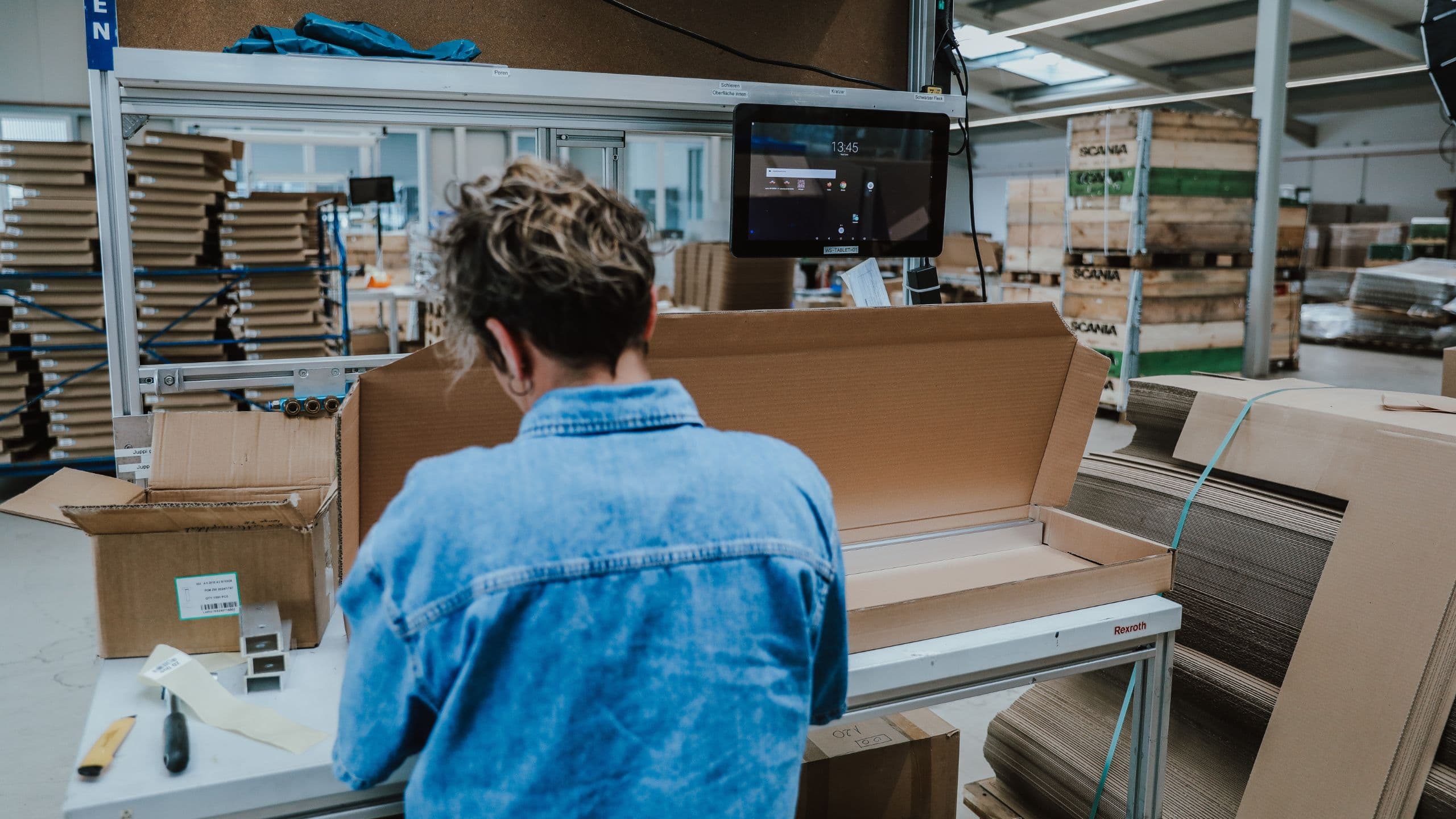 Mitarbeiterin an einem Verpackungsarbeitsplatz bei BKM